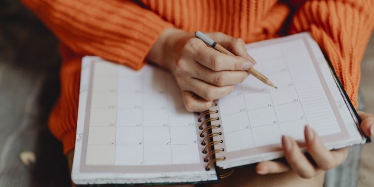 Woman writing dates on calendar